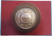 An old fashioned round dial thermostat