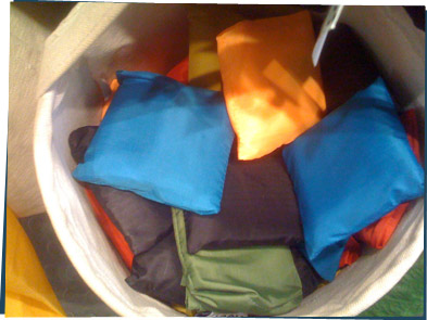 A pile of reusable bags folded up in pouches