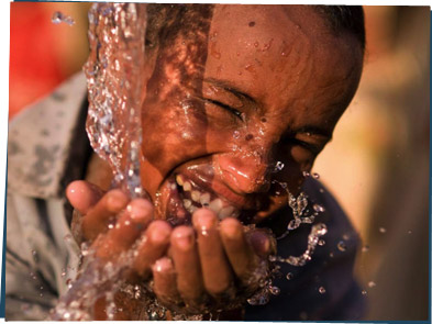A boy splashing water on his face