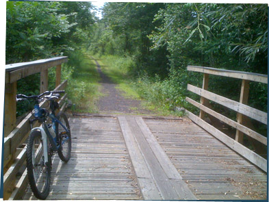 A bike on the side of a long straight path