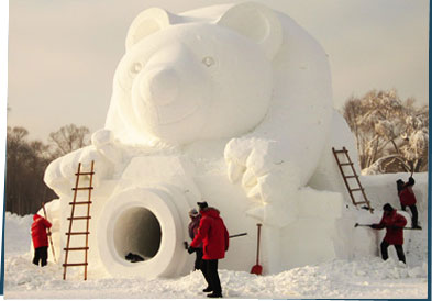 People building a giant snow sculpture of a bear