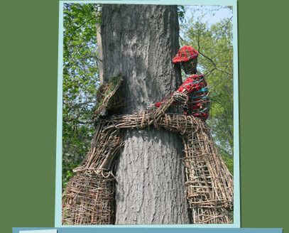 Branch sculptures of a man, woman, and child hugging a tree