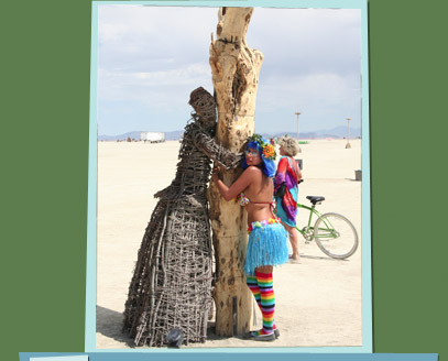 Branch sculpture of a woman hugging a tree in the desert