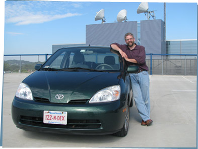 A man standing near his hybrid car